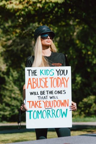 Paris Hilton holding a sign about The 'Troubled Teen' Industry
